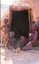 <center>
Ou... Quand la couleur devient tableau ! himba femme enfants assis devant la hutte; kAOKOLAND  NAMIBIE 